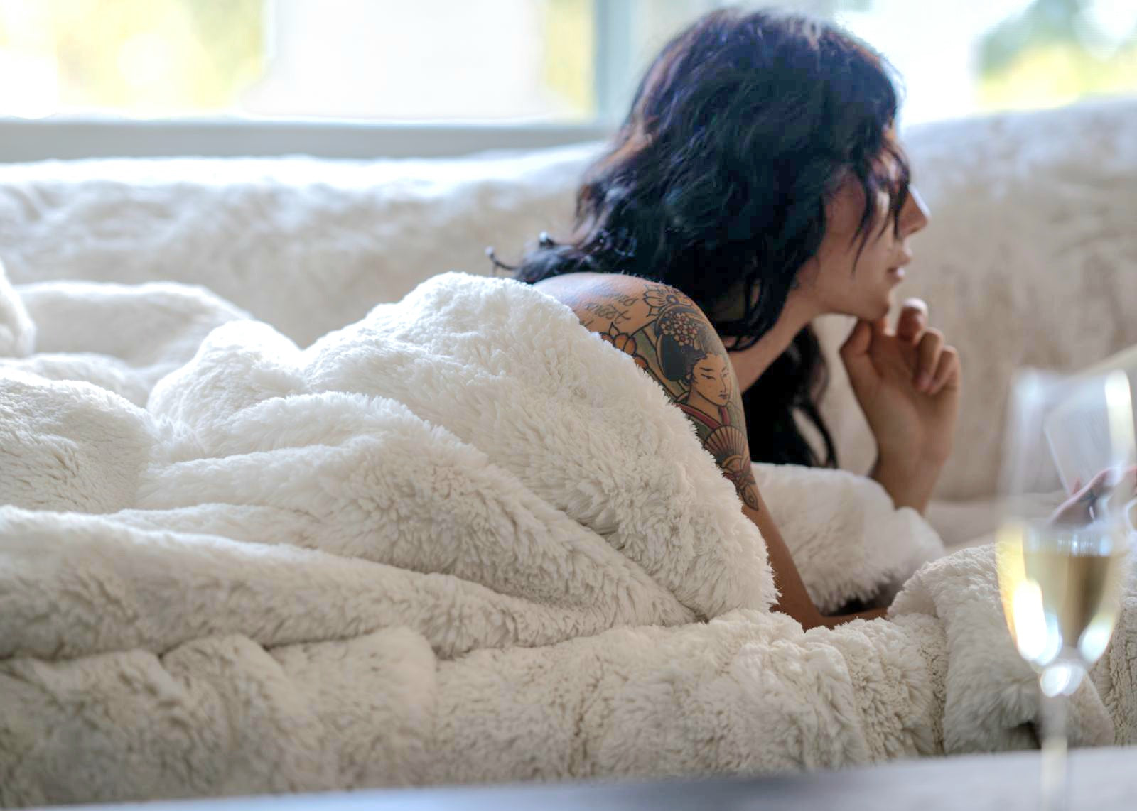 woman modeling plush ivory colored blanket