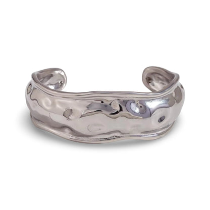 A polished silver cuff bracelet with a hammered