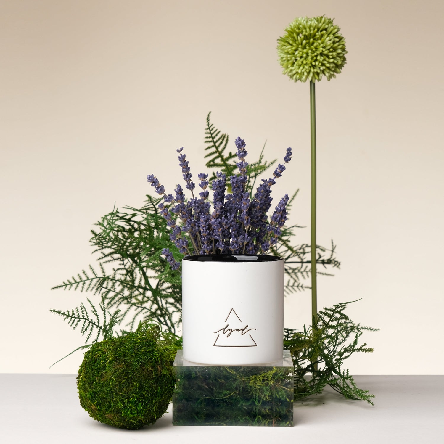 Candle displayed with moss, ferns, and lavender 